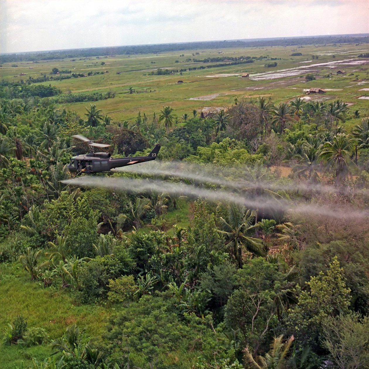 Et UH-1D-helikopter fra 336th Aviation Company sprayer et avløvingsmiddel på et tett jungelområde i Mekong-deltaet, 26. juli 1969 av American Photographer