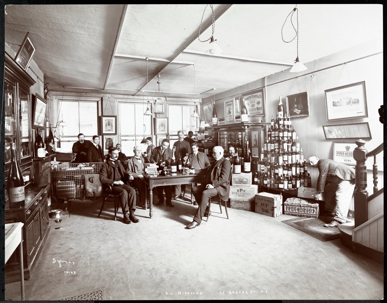 Gruppe menn som drikker vin hos G.L. Nicholas, vin- og brennevinshandlere, 43 Beaver Street, New York, 1895 (sølv gelatintrykk) av Byron Company