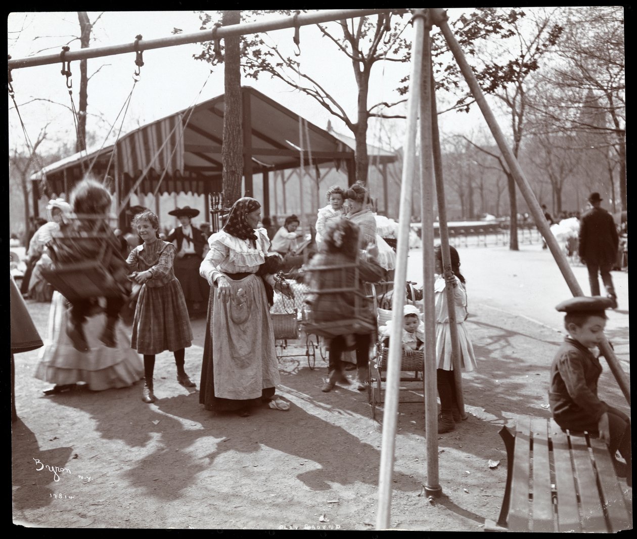 Utsikt over en kvinne som dytter barn på huskene ved Tompkins Square Park, på Arbor Day, New York, 1904 (sølv gelatintrykk) av Byron Company