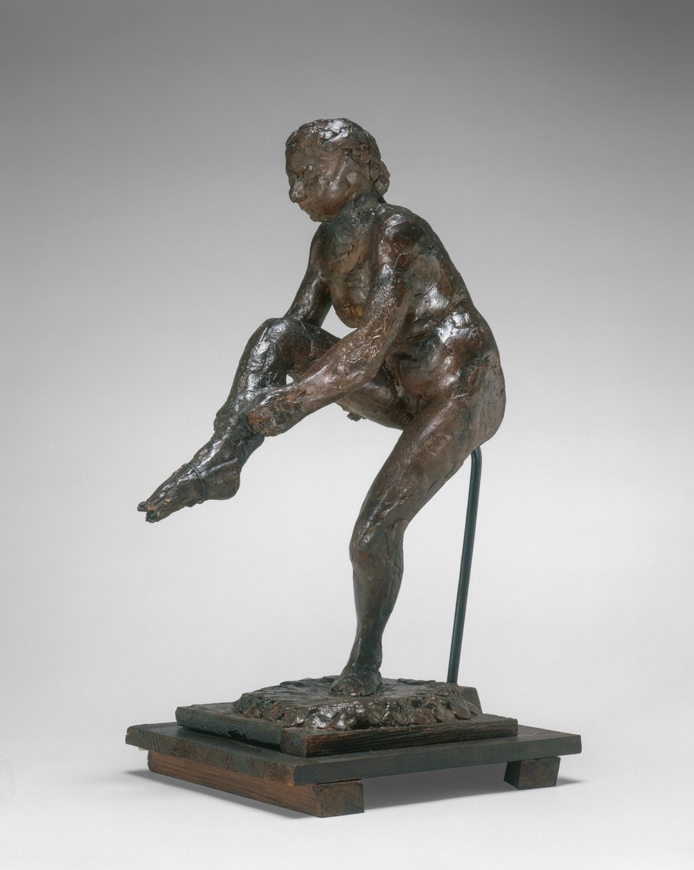Danser tar på seg strømpen av Edgar Degas