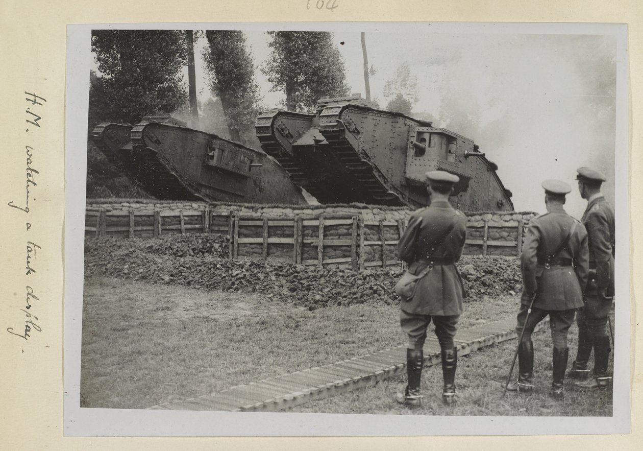 Tre offiserer, en muligens kong George V, så to stridsvogner bli kjørt over en hindring, 1915-18 av English Photographer