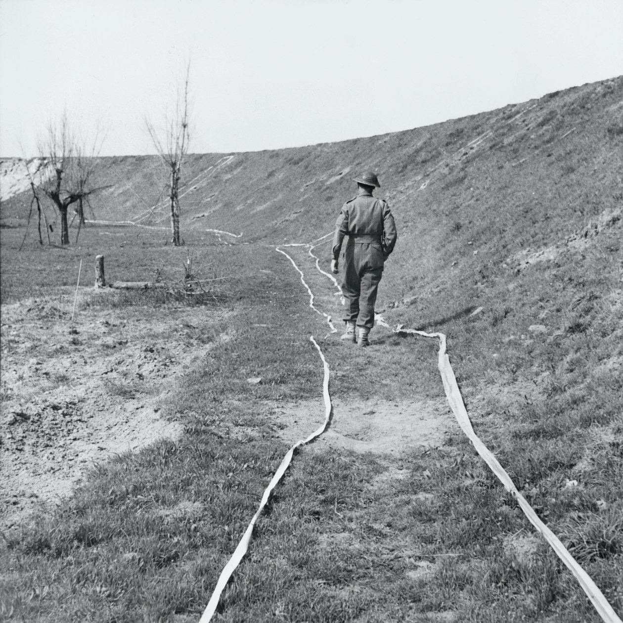 Hvit tape som markerer tydelige spor gjennom et minefelt, ved elven Senio, Italia, mars 1945 av English Photographer