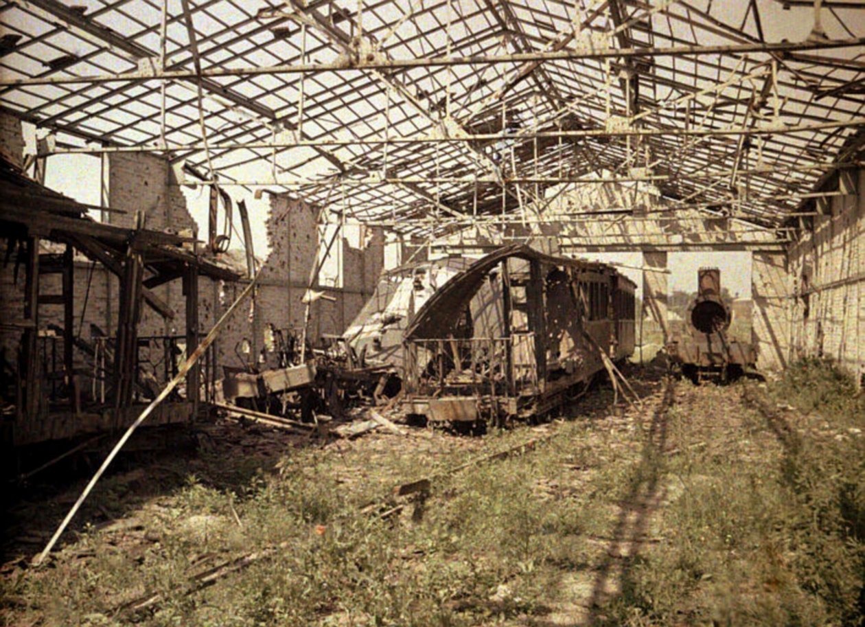 Den utbrente jernbane- og gatebilgården med noen få skadede kjøretøy og et lokomotiv, Soissons, Aisne, Frankrike, 1917 (autokrom) av Fernand Cuville