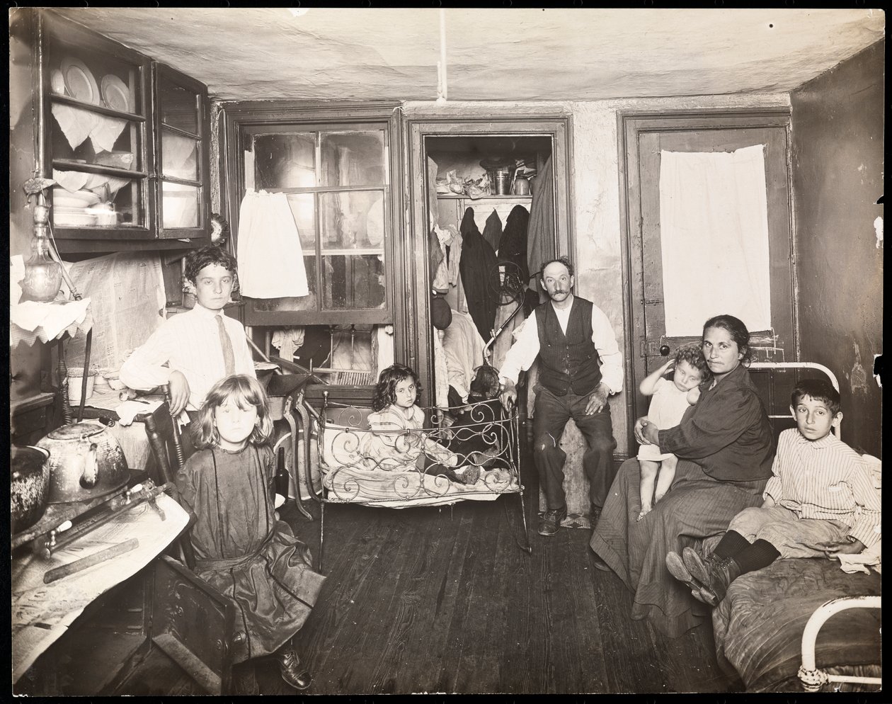 Familie på rom i leiegård, ca. 1910 (gelatinsølvtrykk) av Jessie Tarbox Beals