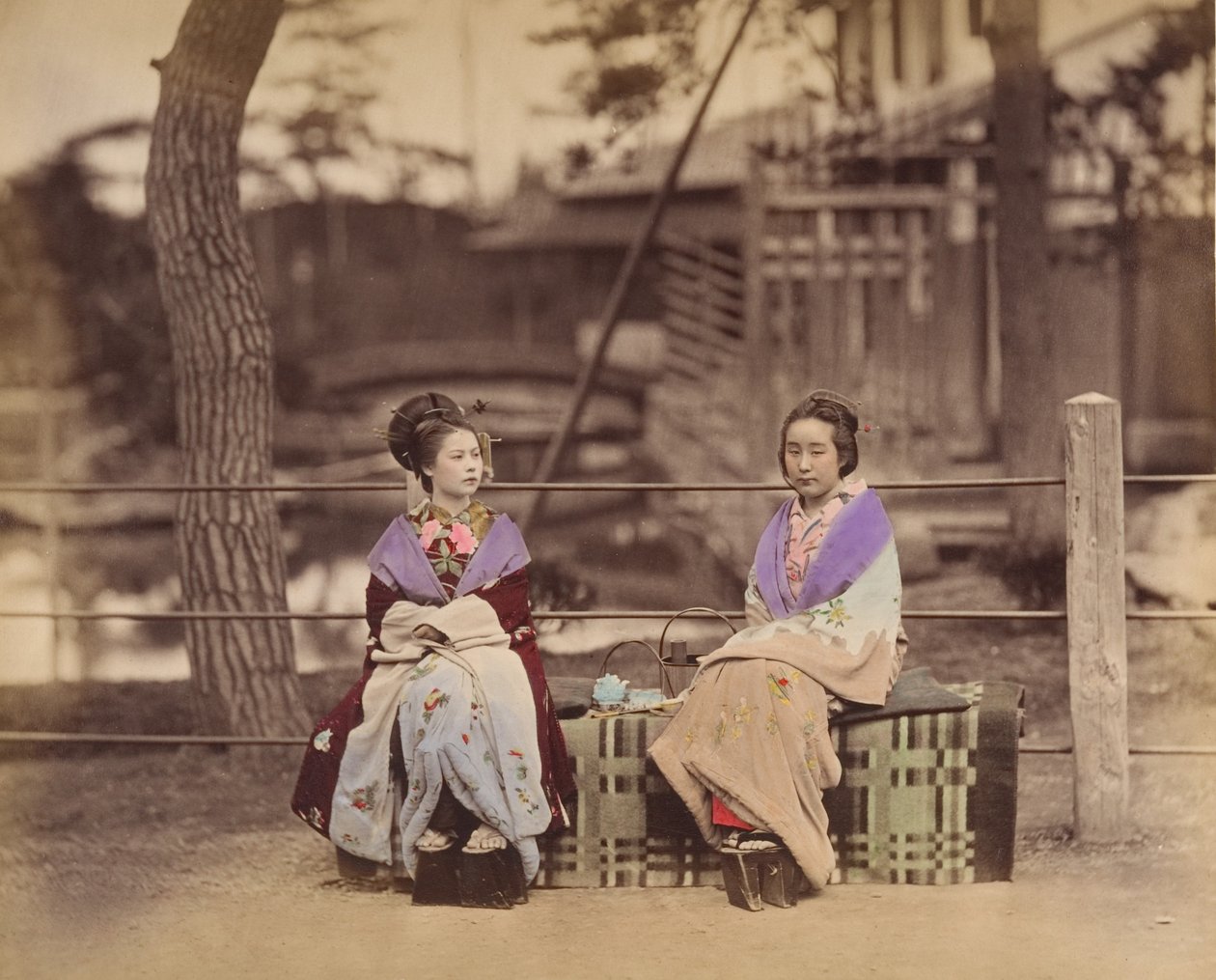 [To japanske kvinner sitter på en benk], 1870-tallet. av Unbekannt
