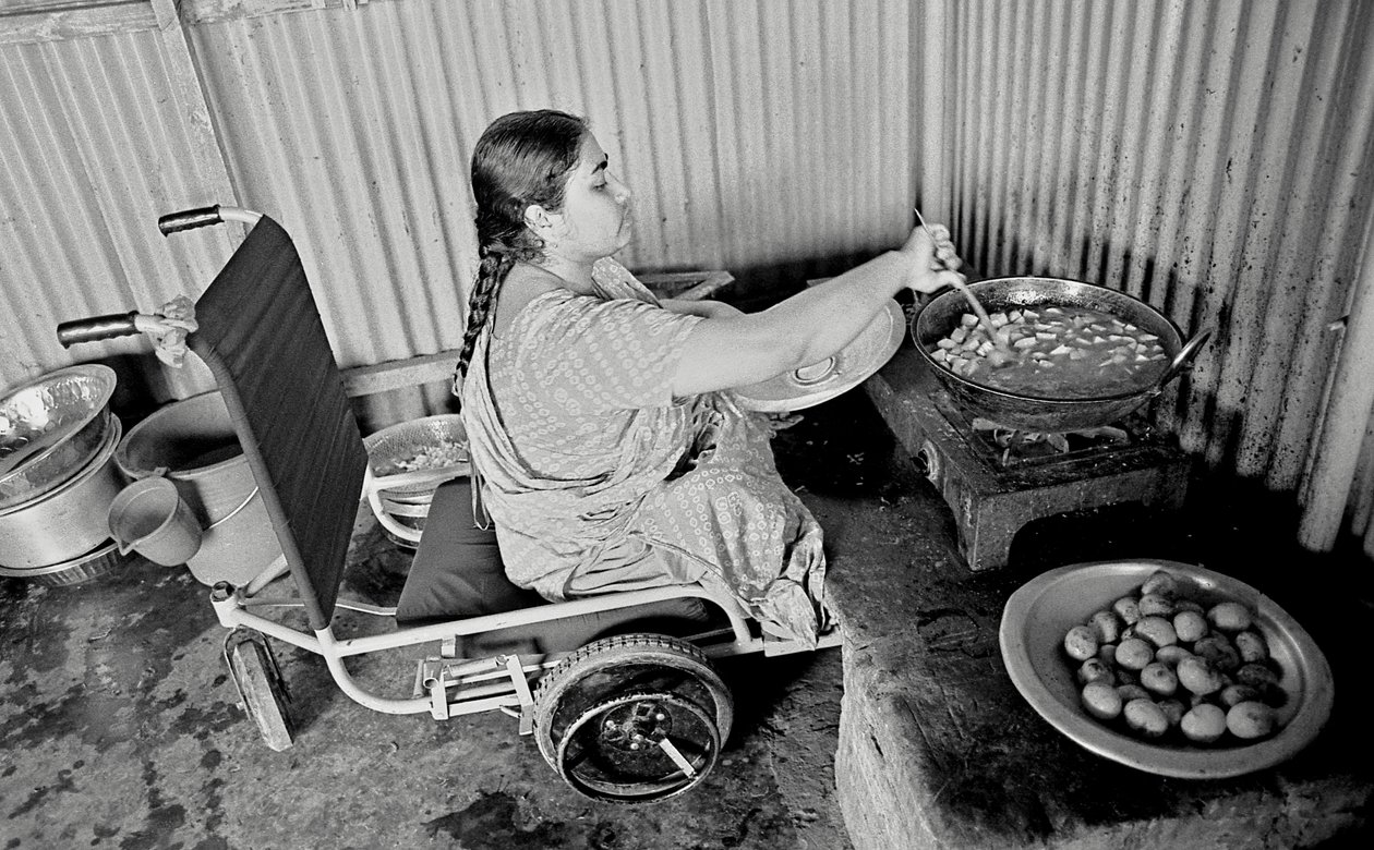 En fysisk utfordret kvinne lager mat til kollegene sine ved The Center for the Rehabilitation of the Paralysed, CRP i Savar, Dhaka, Bangladesh. 2005. av Unbekannt Unbekannt