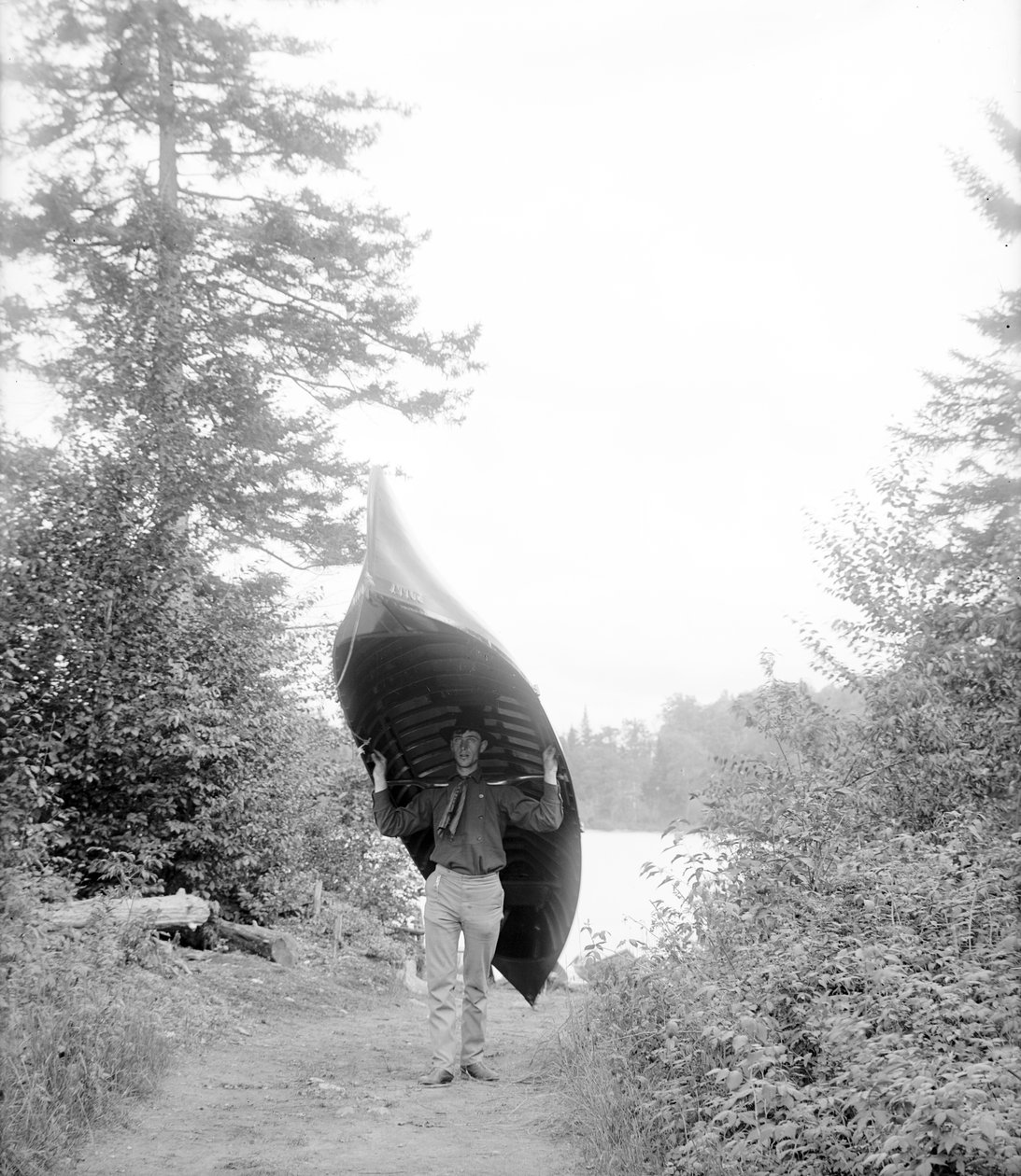 Carrying canoe in the Adirondack Mountains av William Henry Jackson