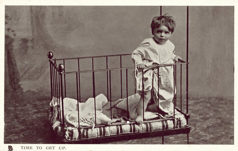 Liten gutt i en barneseng (s/hvitt bilde) av English Photographer
